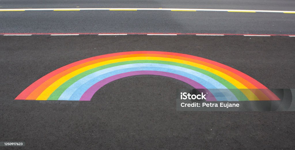 Rainbow on the Street Rainbow motif decoration on the ground next to the bus lane Paint Stock Photo