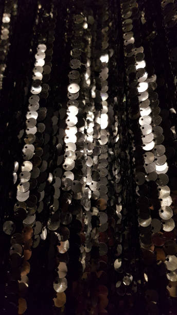 istock Rows of shining surface with silver sequins on blurred black background 1250918727