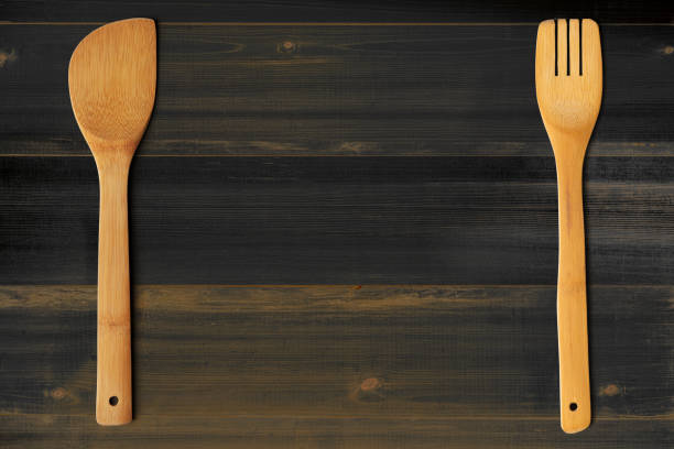 istock Wooden stirrer and fork on dark wooden table. Kitchen and cooking concept. 1250921693
