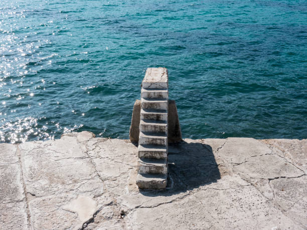 istock Stone stairway on concrete sea breakwater back view 1250921889