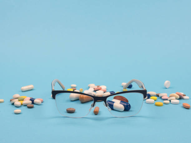 istock Glasses and pills on a blue background. 1250922966