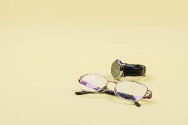 istock Glasses and wrist watch on a yellow background. 1250923240