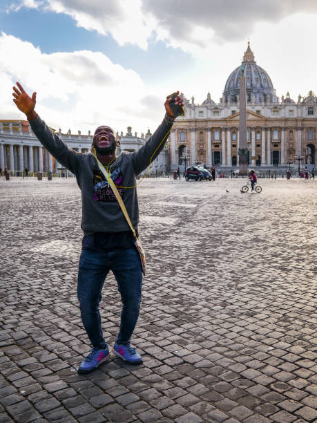 человек молится и поет на площ�ади базилики святого петра в риме - vatican dome michelangelo europe стоковые фото и изображения