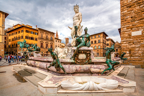 Footpath Sign to Uffizi Gallery at Florence in Tuscany, Italy, with a commercial shop sign visible.