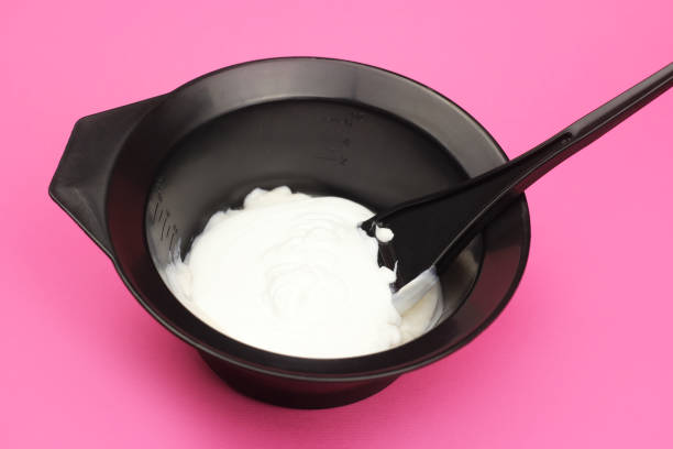 istock Hair dye in a bowl with a brush on a pink background 1250925507