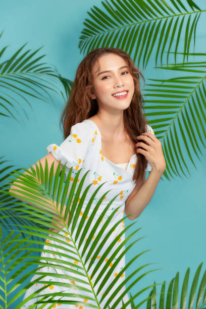 istock Sensual woman against tropical leaves, looking at camera 1250926423