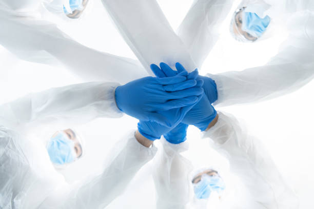 istock Many young researcher team are working on a vaccine to kill coronavirus (Covid-19) and overlapping hands together. Successful on make coronavirus vaccines. Health Insurance and teamwork concept. 1250926861