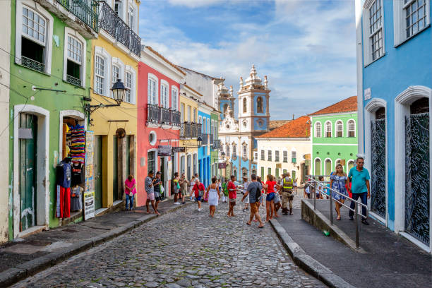 Salvador, Brazil, Upper town - Pelourinho . Salvador, Brazil-March 08, 2020:  Upper town - Pelourinho .
 Pelourinho is the old historic center of Salvador. Here you can see the largest collection of different types of colonial architecture in Latin America. It is no accident that the historical center of the city was declared a UNESCO world heritage site. The blue Church of Nossa Senhora do Rosario DOS Pretus is visible in the center of the image. The Church was erected in 1704 by slaves from Africa in their spare time from hard labor, often at night.Built almost a hundred years. Tourists walk around the city. Central America stock pictures, royalty-free photos & images