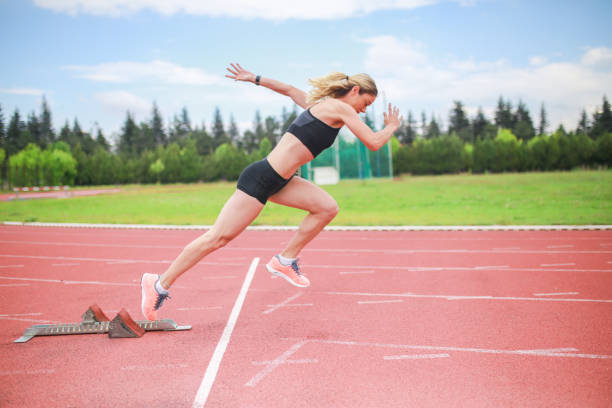 istock Track athlete exploding out of the starting blocks in stadium 1250928833
