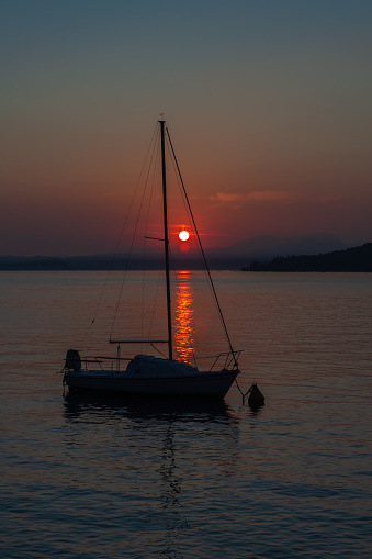 Sailboat moored on Lake Garda, Italy with a beautiful sunset.