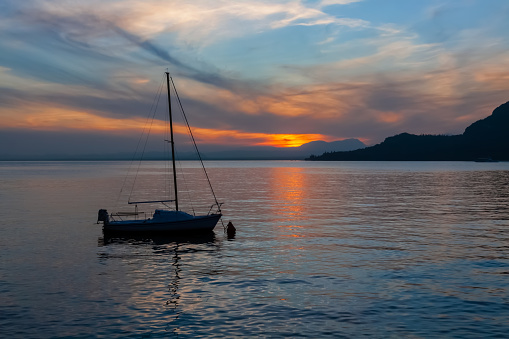 Sailboat moored on Lake Garda, Italy with a beautiful sunset.