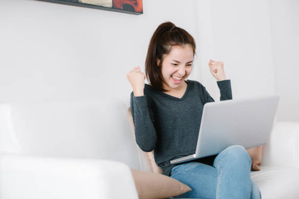istock Euphoric and surprised winner winning online watching a laptop at home 1250931440