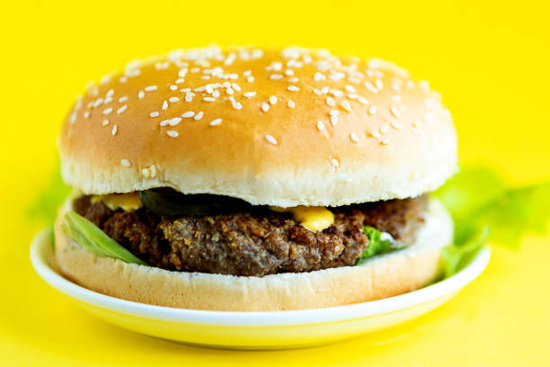 istock Fresh tasty hamburger on bright yellow background 1250939936