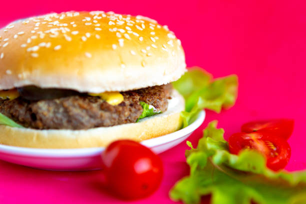 istock Fresh tasty hamburger on bright red background 1250939961