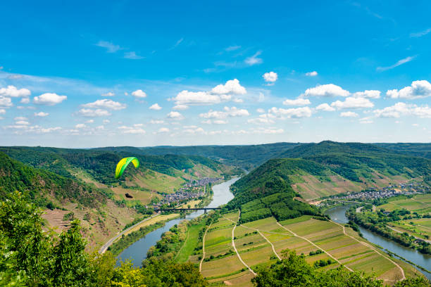 Paraglider at the Devil's Mill in the Black Forest in front of the panorama of the Murg Valley, Rhine Valley and Vosges in the golden evening sun.