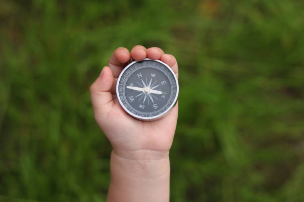 istock classic navigation compass in childs hand on natural background 1250943381