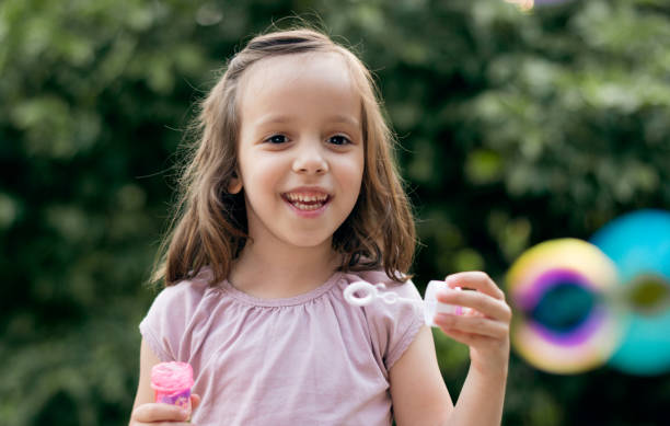 istock Child having fun and blowing bubbles outdoors 1250946535