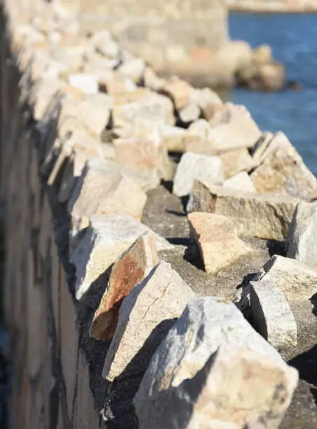 Sharp jagged rocks along the top edge of a retaining wall.