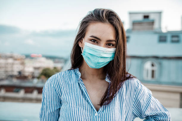 istock Young woman with face mask on the rooftop 1250950996