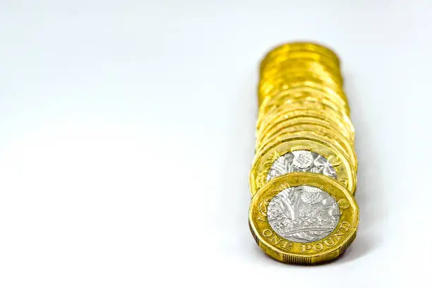 Photo of Column of British one pound coins on a white background