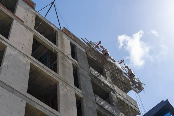 istock Construction workers plaster the facade of the house. Application Of Facade Plaster. Elevation of the building. Workers are plastering the facade of the building. 1250956618