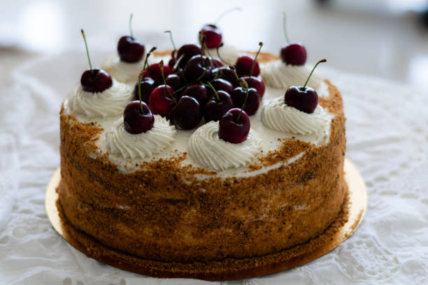 istock Medovik - layered russian honey cake garnished  with fresh cherries 1250960454