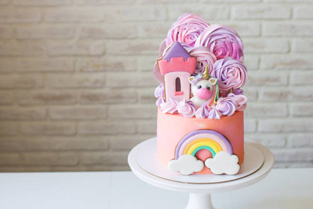 cute pink birthday cake for a little girl with fondant unicorn, gingerbread princess castle, rainbow and meringue. - little cakes imagens e fotografias de stock