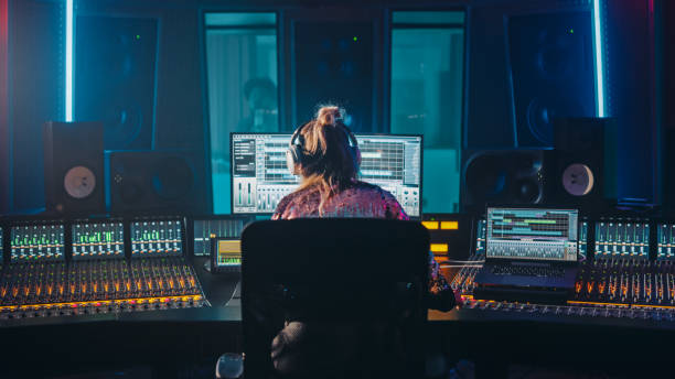 künstler, musiker, audio engineer, producer in music record studio, verwendet control desk mit computerbildschirm, der software-ui mit song playing zeigt. tänze. rückansicht - toningenieur stock-fotos und bilder