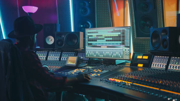 istock Portrait of Audio Engineer Working in Music Recording Studio, Uses Mixing Board Create Modern Sound. Successful Black Artist Musician Working at Control Desk. 1250963426