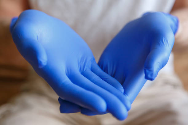 istock Men's hands in medical gloves hold something. 1250964532