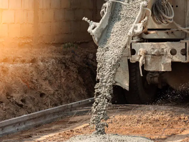 Photo of Pouring ready-mixed concrete after placing steel reinforcement to make the road by mixing in construction site