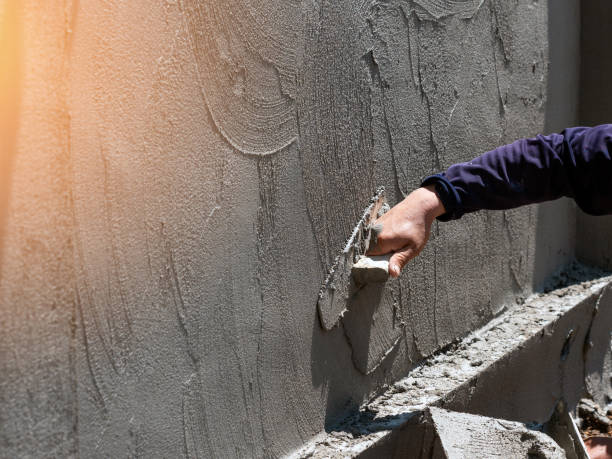 plasterer concrete worker at wall of house construction site - plasterer construction site manual worker plaster imagens e fotografias de stock