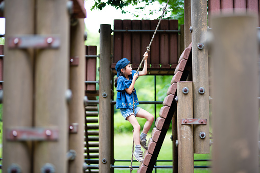 Girl climbing a rope in the park