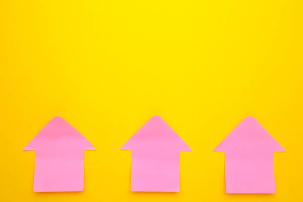 istock Pink paper sticky notes in shape of arrow on yellow background 1250971107
