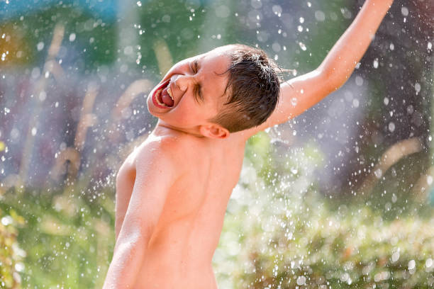 istock Cute boy dancing in the summer rain 1250972914