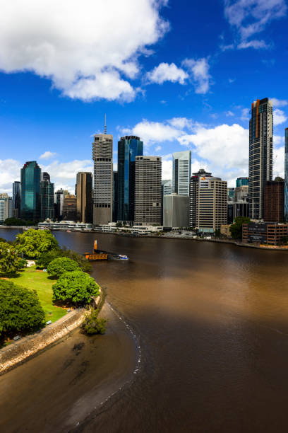 A residential area seen behind the Brisbane River in Brisbane, Australia, a cloudy day in the summer.