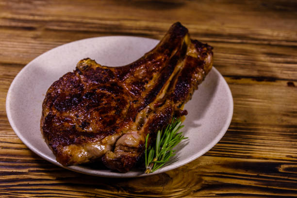 istock Plate with roasted ribeye steak on wooden table 1250980925