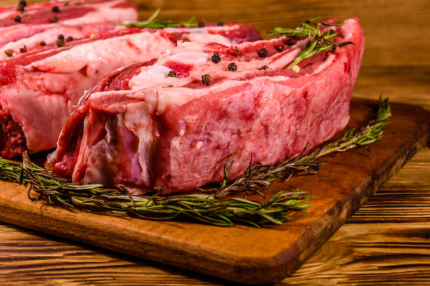 istock Raw pork ribs with spices and rosemary on a cutting board 1250980930
