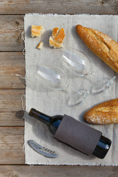 French baguette, wine glasses and bottle of red wine