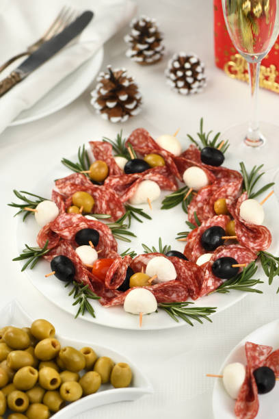 weihnachtskranz - antipasto. salami-kanapees mit oliven, baby-mozzarella. - salami sausage portion decoration stock-fotos und bilder
