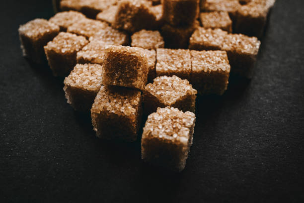 istock Brown cane sugar in cubes on a black background. 1250984477