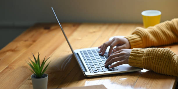 istock A woman's hands using a white blank screen computer laptop at the wooden working desk. 1250984690