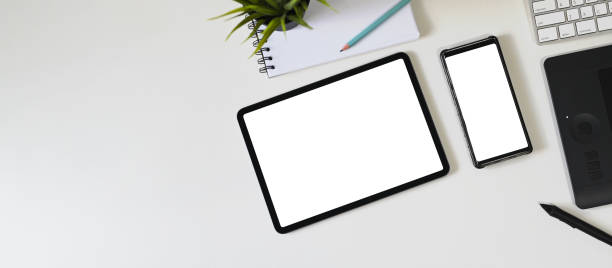 istock Top view image of white blank screen computer tablet and smartphone are putting on a workspace. 1250985393
