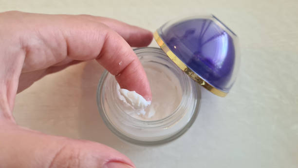 istock A finger taking a bit of cream from round glass container 1250990032