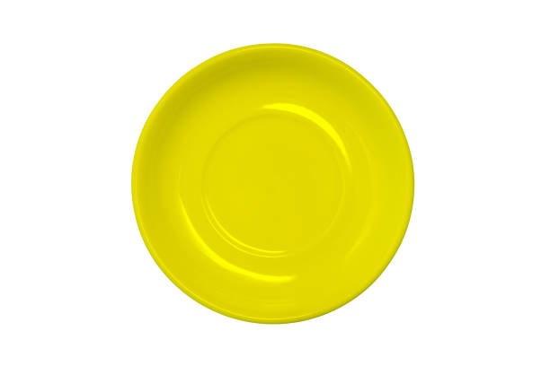 istock An empty yellow plate isolated on a white background. Colored dishes for food for Breakfast, dinner or lunch. Kitchen items. A top view of a flat layout. 1250994420