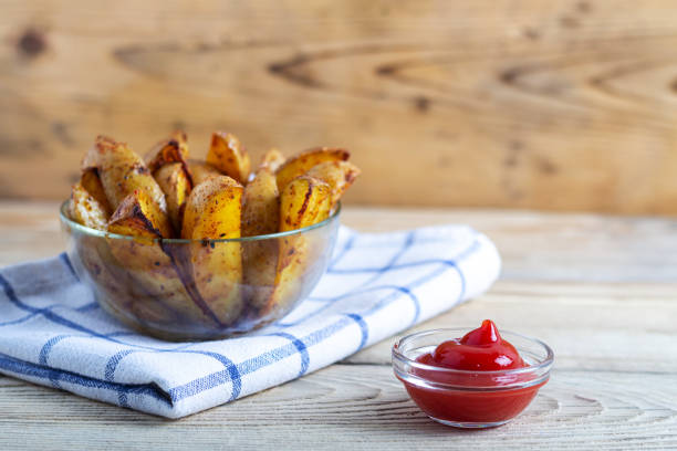 istock Fried potatoes with ketchup on a white towel on a wooden table with copy space 1250996800