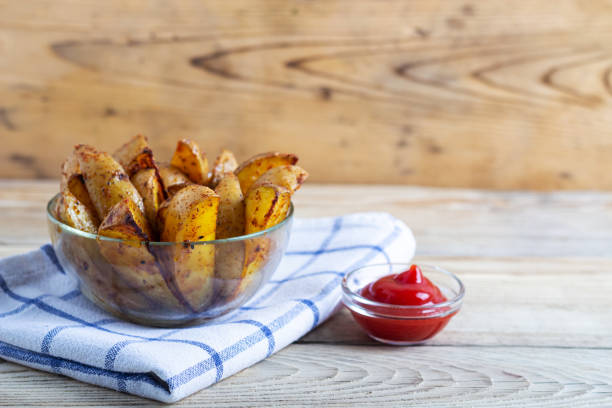 istock Fried potatoes with ketchup on a white towel on a wooden table with copy space 1250996813