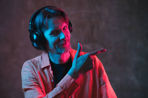 istock Adult man with colored neon lighting on dark background. 1250998190