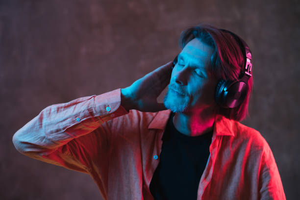 istock Adult man with colored neon lighting on dark background. 1250998200