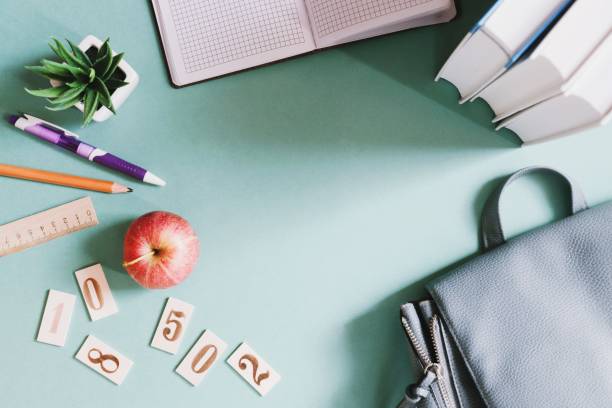 istock Back to school flat lay composition photography. Books, stationery, backpack and red apple on a green table. Education concept 1251000179